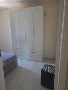 een slaapkamer met een bed en een grote witte kast bij Beachfront Apartment in Itanhaém