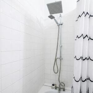 een douche in een wit betegelde badkamer bij A spacious room in a strategic area in Montrouge +5 foto's