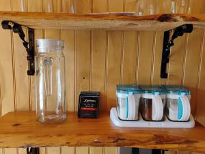 een plank met vier kopjes en een glazen pot erop bij Cabaña colonia río sur in Puerto Varas +15 foto's