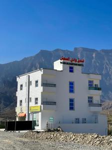 a white building with a sign on top of it at فندق وادي السحتن in Al Ambaḩ