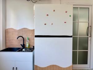 una cucina con mobili bianchi e un frigorifero di Nana Best Hostel a Makkasan
