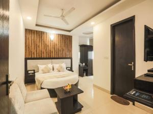 een hotelkamer met een bed en een bank bij Hotel Signature Suites Near Delhi Airport in New Delhi