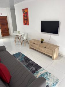 a living room with a flat screen tv on a wall at KLAAK hotel and Apartments in Ga-Masamothane +9 photos