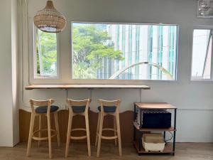 una cucina con tre sgabelli da bar e un bancone con una finestra di Nana Best Hostel a Makkasan