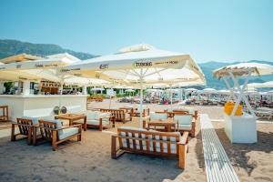 een groep tafels en parasols op een strand bij Hotel Harmonia by Dukley in Budva