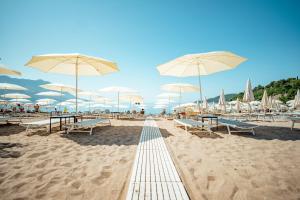 een strand met stoelen en parasols op het zand bij Hotel Harmonia by Dukley in Budva