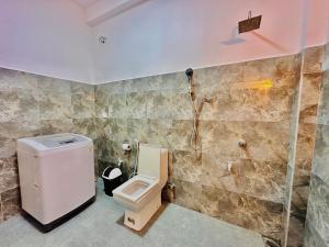 een badkamer met een toilet en een douche bij In Dream Villa in Rekawa