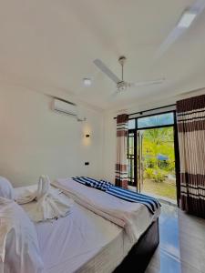 een slaapkamer met twee bedden en een groot raam bij In Dream Villa in Rekawa