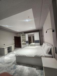 OktyabrʼGrand Hotel的卧室里有一张白色的大床和一面镜子