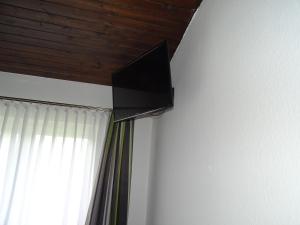 a flat screen tv on a wall next to a window at Landhaus Waldrand in Biersdorf am See