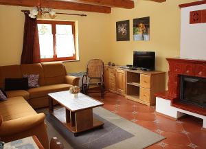 a living room with a couch and a tv at Chata Dominika - Tále in Bystrá