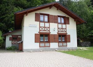 a house with wooden windows and a brick driveway at Chata Dominika - Tále in Bystrá