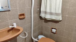 卡雅泽拉斯Qt bem localizado e Confortável -Centro的一间带水槽、卫生间和毛巾的浴室