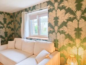 een woonkamer met een bank en een raam bij Aux Berges Du Mont - Parking, 10 min Mont-Saint-Michel & Jardin in Pontorson