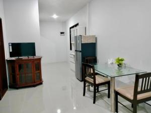 a dining room with a table and a television at ปารมีฟาร์มสเตย์ in Ban Chao Nam +21 photos
