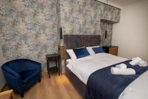 ein Schlafzimmer mit einem Bett und einem blauen Stuhl in der Unterkunft Amber Hotel Double Room in Hull