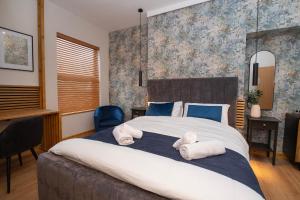 ein Schlafzimmer mit einem großen Bett, auf dem Handtücher liegen in der Unterkunft Amber Hotel Double Room in Hull