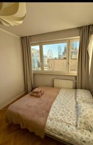 een slaapkamer met een groot bed en een raam bij Złota Palace View Retreat in Warschau