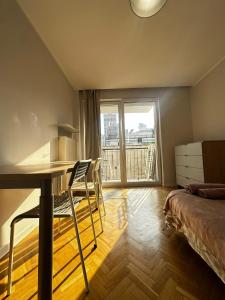 een slaapkamer met een bureau, een bed en een raam bij Złota Palace View Retreat in Warschau