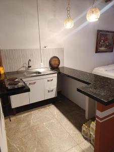 a kitchen with a sink and a counter top at Divas do mar kitnet 7 in Ilhéus