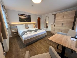 una camera da letto con un letto, un tavolo e delle sedie di Haus Luise a Bad Hindelang