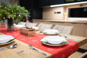 a table with plates and silverware on a red table cloth at Chalet Horizont in Ižipovce