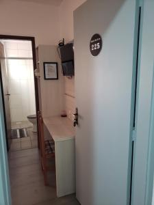een deur naar een badkamer met een wastafel en een toilet bij Hotel leo in Pelotas