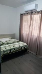 een slaapkamer met een bed en een gordijn bij Hotel leo in Pelotas