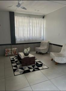 een woonkamer met twee stoelen en een salontafel bij Hotel leo in Pelotas