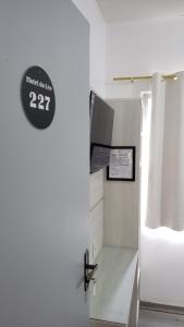 een witte kamer met een klok aan de muur bij Hotel leo in Pelotas