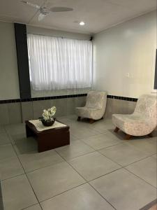 twee stoelen en een tafel in een wachtkamer bij Hotel leo in Pelotas +17 foto's