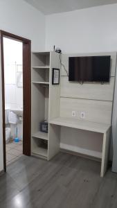 een woonkamer met een tv aan de muur bij Hotel leo in Pelotas