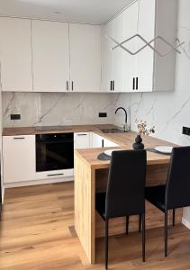 een keuken met een houten tafel en witte kasten bij New Business-Class Apartament з генератором Varshavsky Retroville in Kiev