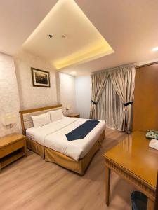 een hotelkamer met een bed, een tafel en een bureau bij صفاء المسكن in Dammam