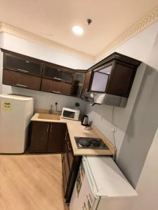 een kleine keuken met een spoelbak en een koelkast bij صفاء المسكن in Dammam