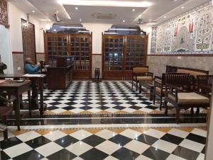 a person sitting at a podium in a room with a checkered floor at Hotel Har Niwas udaipur city of lakes in Udaipur
