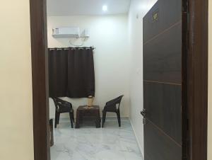 a room with two chairs and a table and a window at Hotel Pampa Sarovar in Chhatarpur