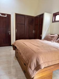 a bedroom with a large bed with wooden cabinets at Rumah Cahaya Syariah Peaceful Family Home in Rampal