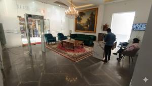 een man in een woonkamer met een bank bij Hotel Tark Premium New Delhi in New Delhi