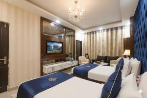 een hotelkamer met twee bedden en een bank bij Hotel Tark Premium New Delhi in New Delhi