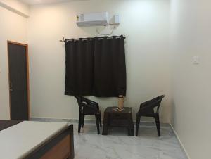 a room with two chairs and a table with a air conditioner at Hotel Pampa Sarovar in Chhatarpur