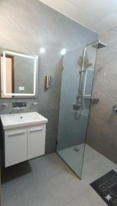 een badkamer met een glazen douche en een wastafel bij Hotel Tark Premium New Delhi in New Delhi