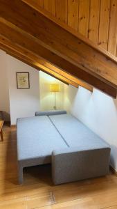 een bed in een kamer met een houten plafond bij Casa La Muga in Benasque