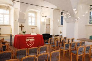 een kamer met een tafel en stoelen in een kerk bij Gut Beinrode in Kallmerode