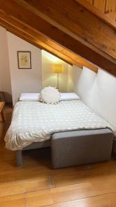 een groot bed in een kamer met een houten vloer bij Casa La Muga in Benasque