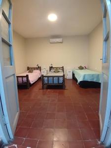 een kamer met 2 bedden en een tegelvloer bij La Casona Hostel CUENTA OFICIAL in Bermejo