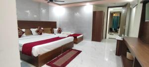 a bedroom with a large bed and a bathroom at Hotel Gloria Rishikesh in Rishīkesh