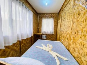 a room with a bed with a stuffed animal on it at The Tribe Apartment in Port Barton