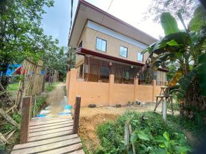 a house with a fence in front of it at The Tribe Apartment in Port Barton