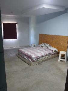 a bedroom with a bed in a room with a window at Plumas verde, casa campo in Médano de Oro